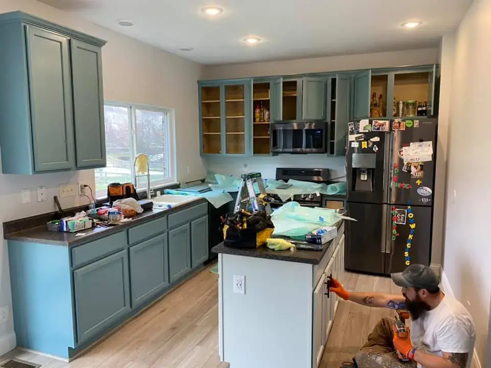 In progress: kitchen wood cabinets painted teal with a white island