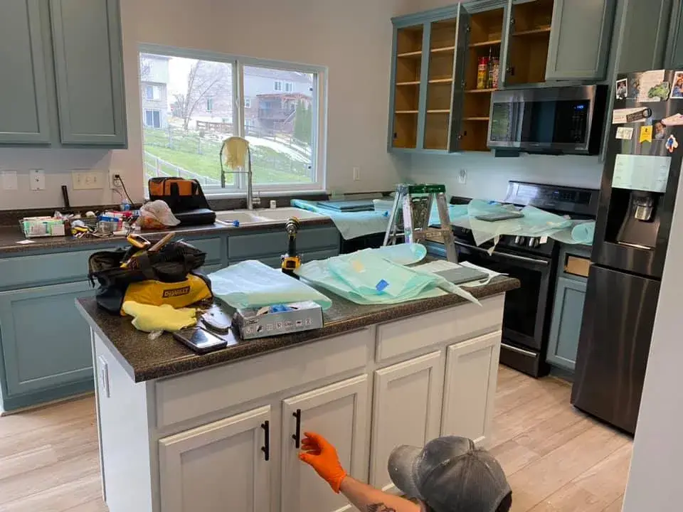 In progress: kitchen wood cabinets painted teal with a white island