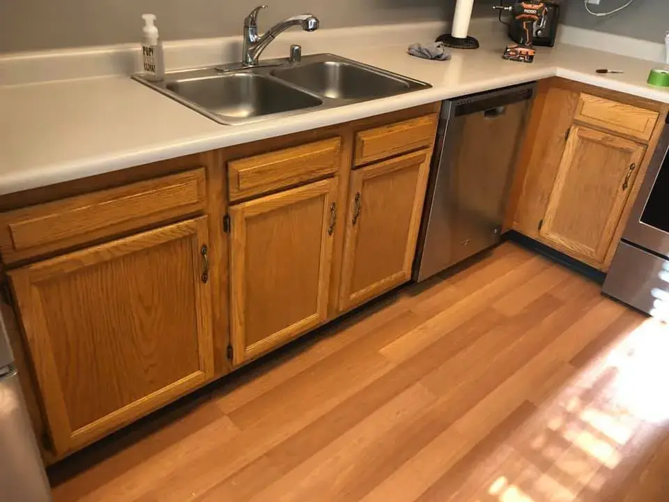 Before: kitchen wood cabinets painted white (patterned tile wall, HOME sign)