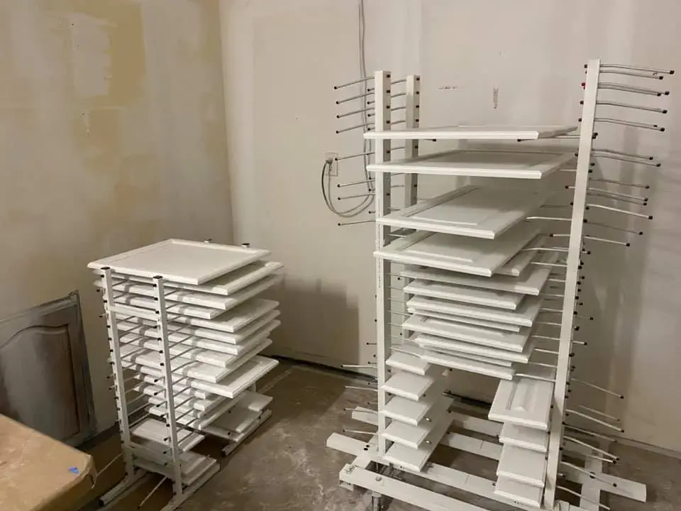 In progress: kitchen wood cabinets painted white (patterned tile wall, HOME sign)