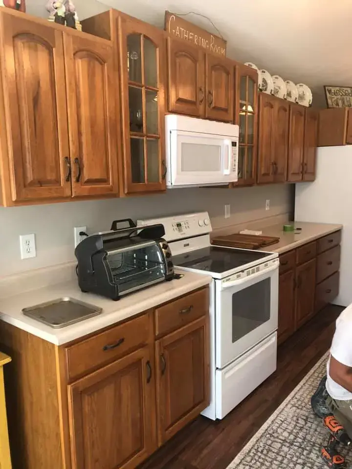 Before: kitchen wood cabinets painted white uppers, dark lowers