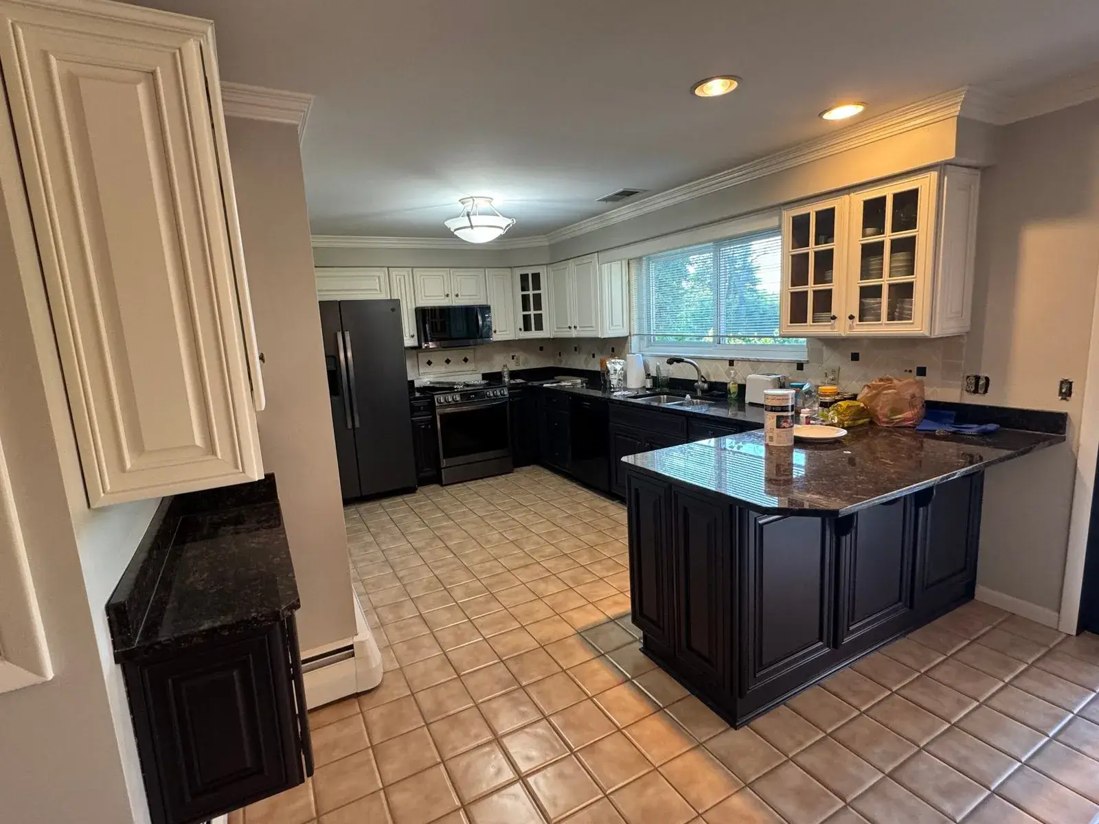 After: kitchen wood cabinets to white uppers with a dark peninsula