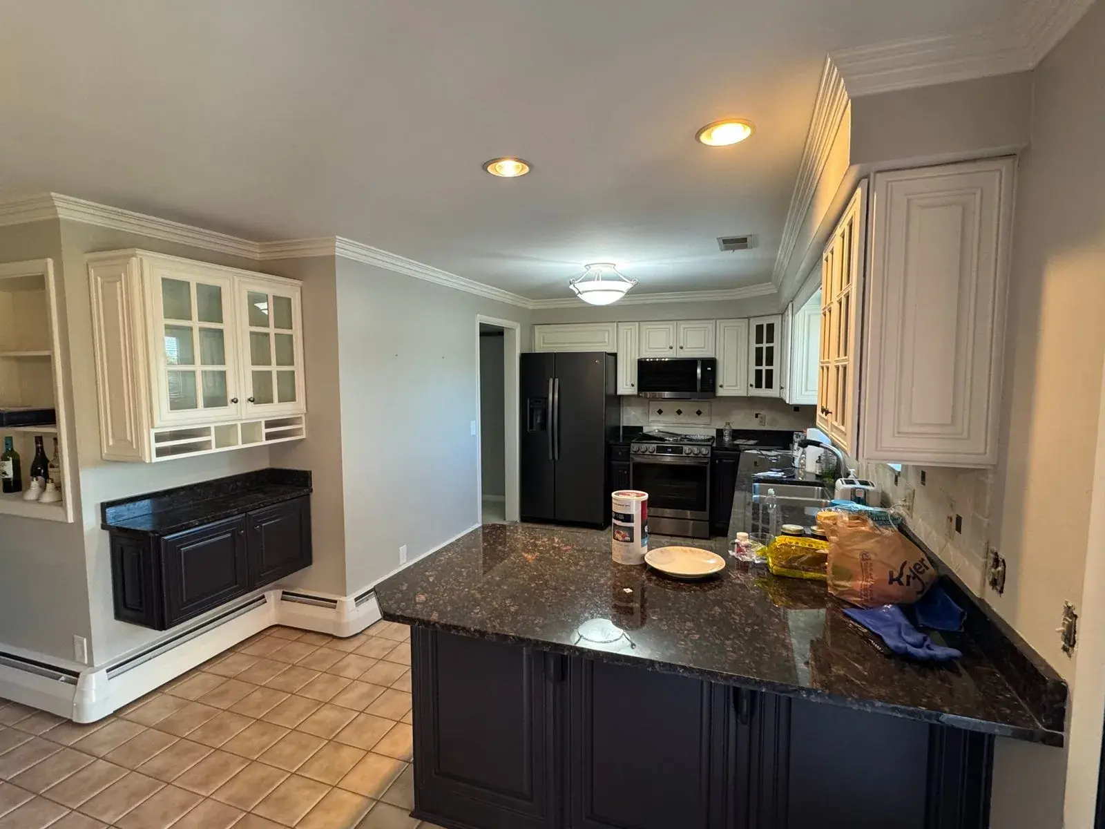 After: kitchen wood cabinets to white uppers with a dark peninsula