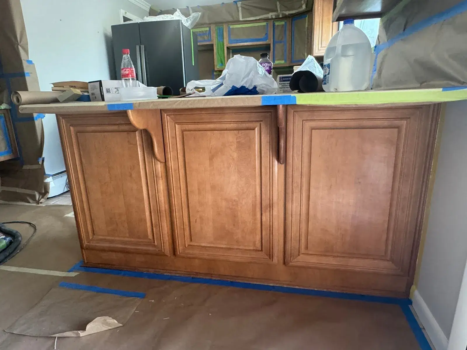 Before: kitchen wood cabinets to white uppers with a dark peninsula