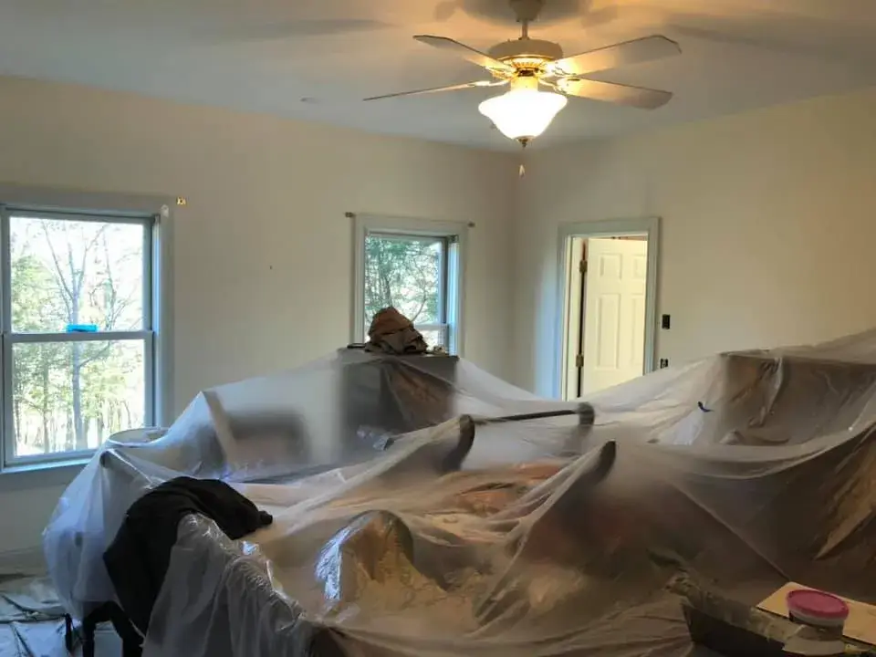 Furniture covered with plastic sheeting in a room during a renovation. - My Personal Painter - My Personal Painter In progress: lime green kitchen walls, accent walls, hallway and French doors