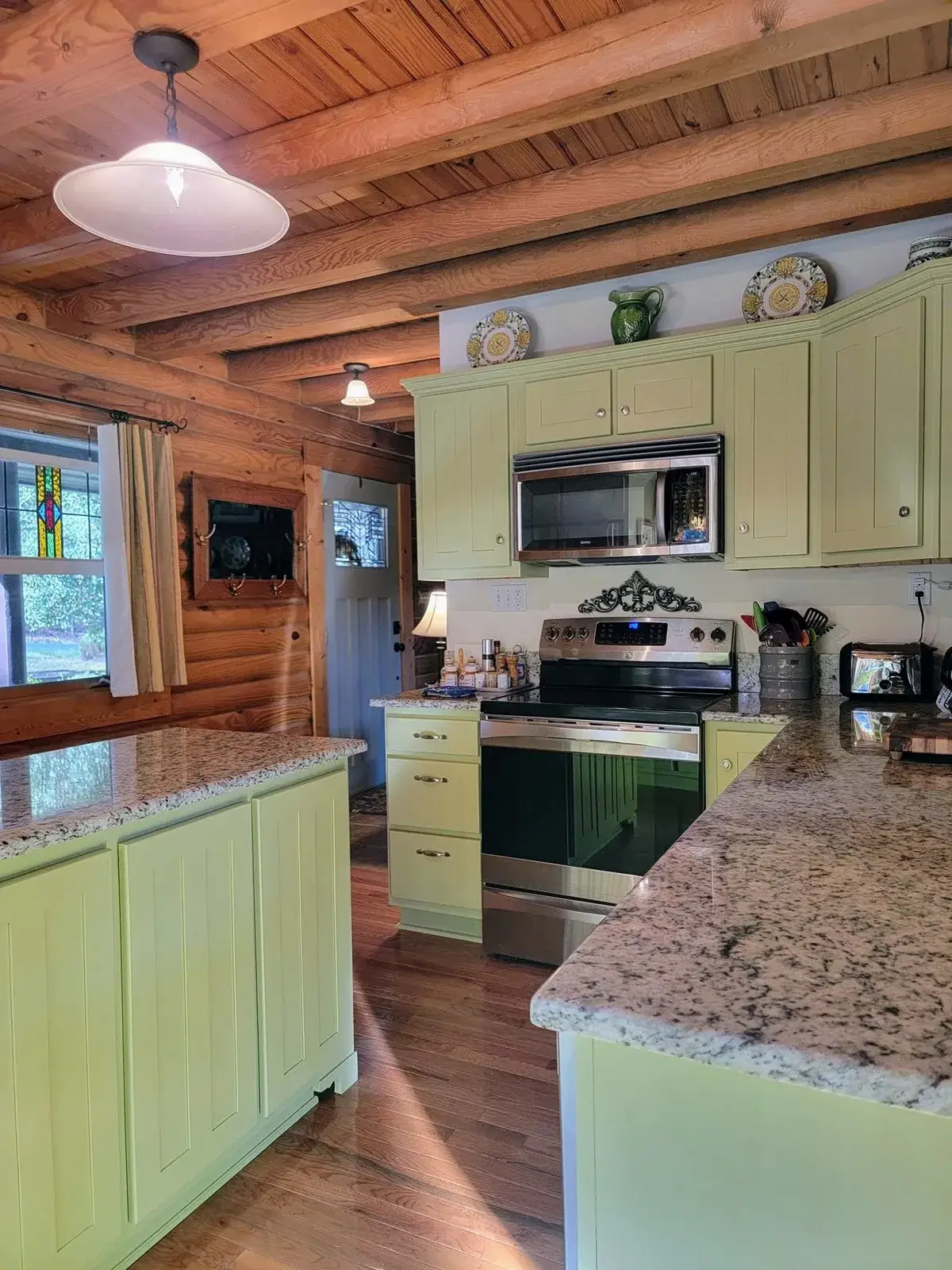 After: log cabin kitchen painted green