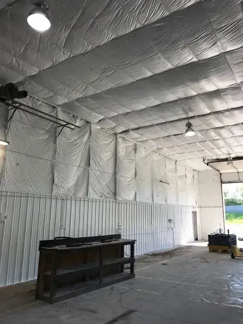 After: metal building interior: walls painted white under insulated fabric ceiling
