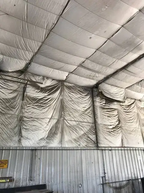 Insulated fabric panels lining the interior walls and ceiling of a warehouse structure. - My Personal Painter - My Personal Painter In progress: metal building interior: walls painted white under insulated fabric ceiling