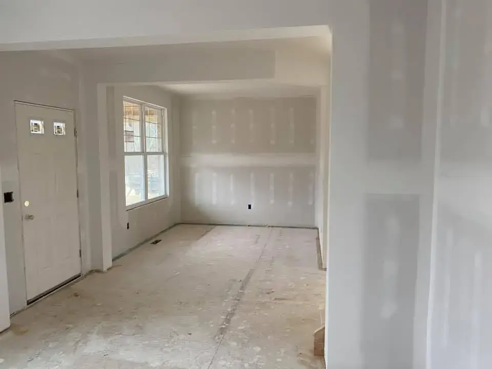 Interior of a room under construction with bare drywall and an unfinished floor. - My Personal Painter - My Personal Painter In progress: new-construction interior walls painted