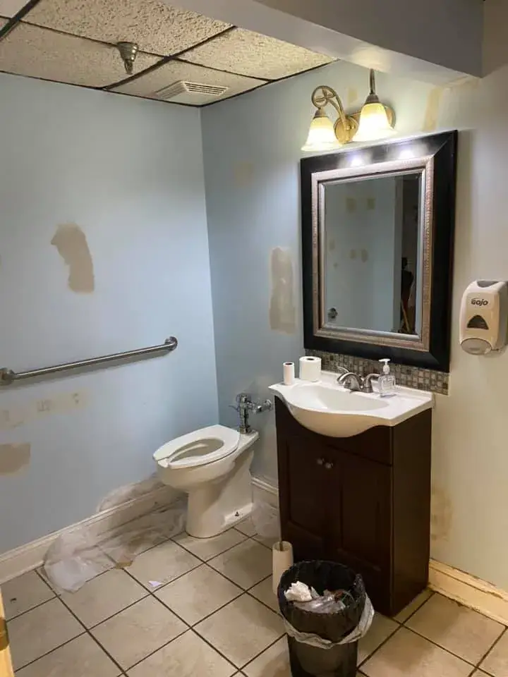 Before: office interior repainted: red accent wall, waiting room, hallway, restroom