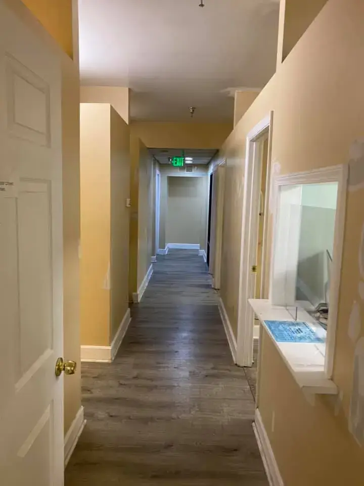 Before: office interior repainted: red accent wall, waiting room, hallway, restroom