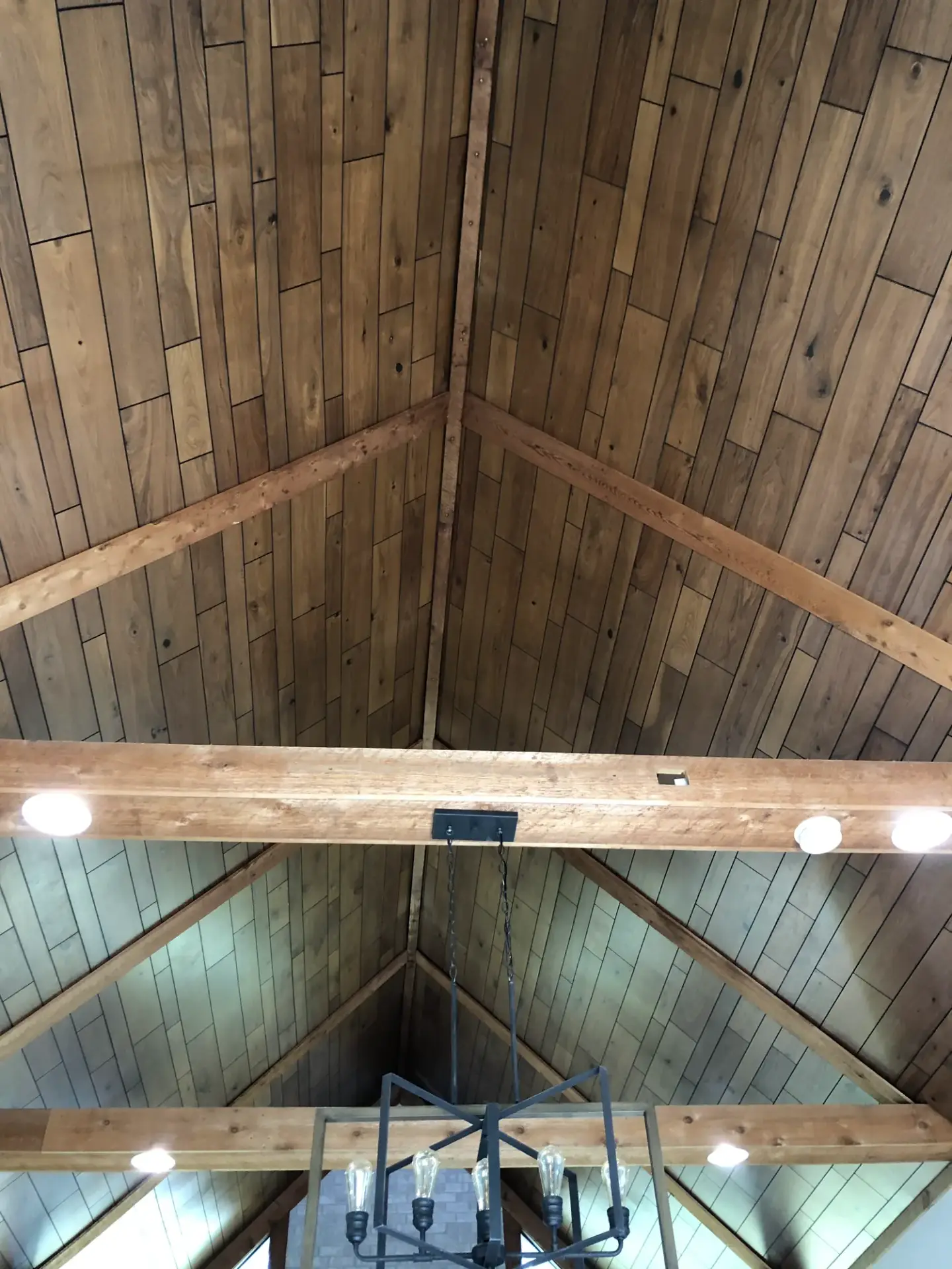 Vaulted ceiling with stained wood planks and beams before painting