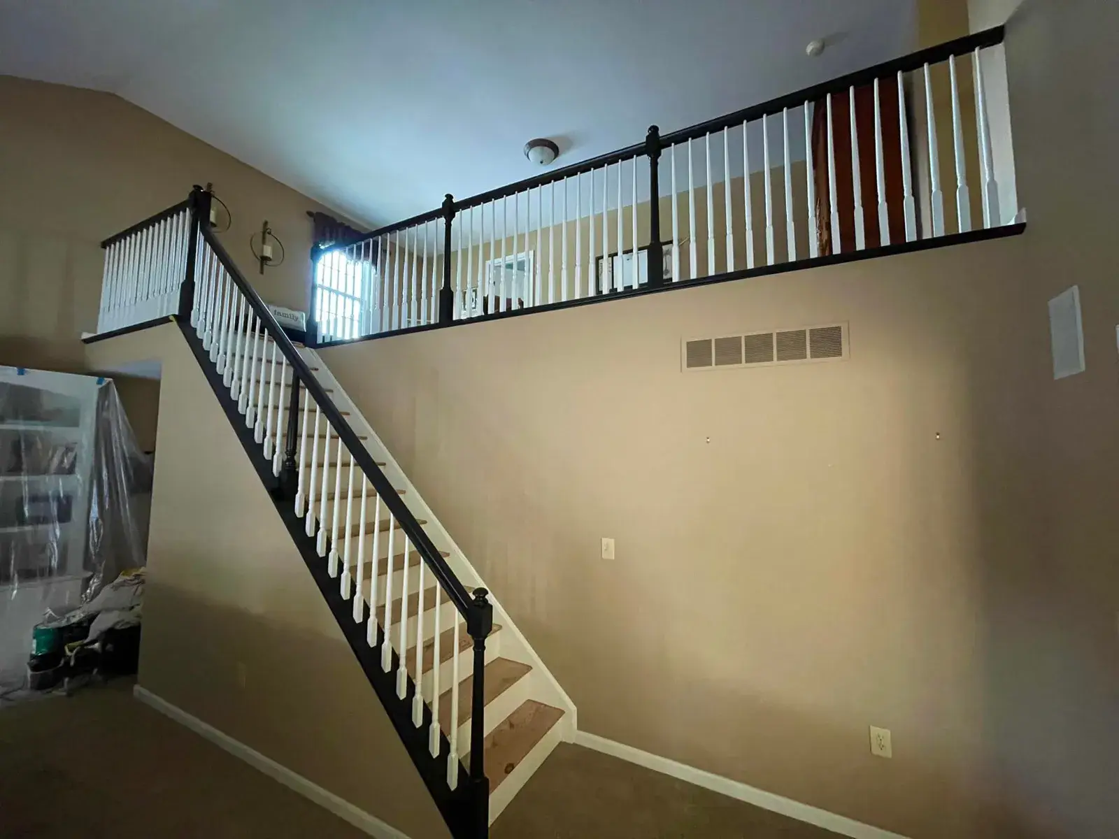 Staircase with black handrails and white balusters leading to an upper landing overlook. - My Personal Painter - My Personal Painter After: staircase: oak railing painted black with white spindles and black treads