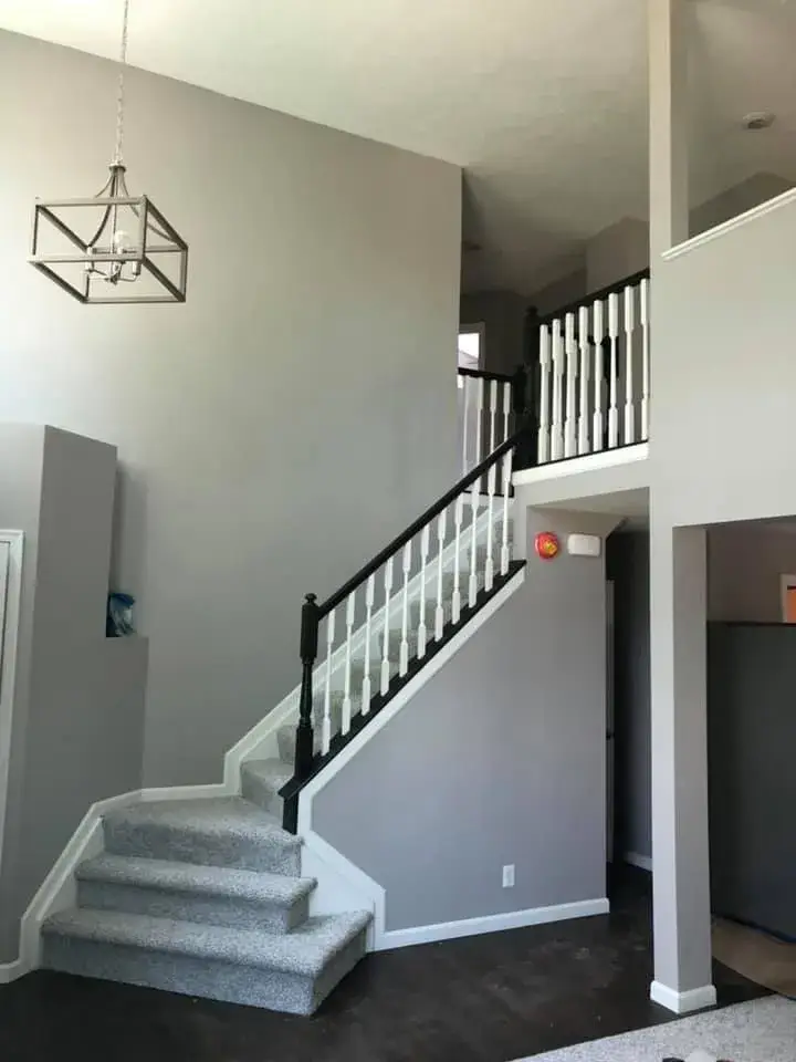 After: two-story foyer and rooms painted gray, stair railing painted black