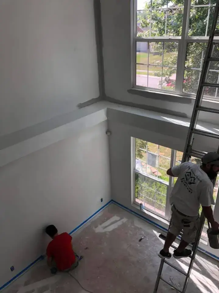 In progress: two-story foyer and rooms painted gray, stair railing painted black