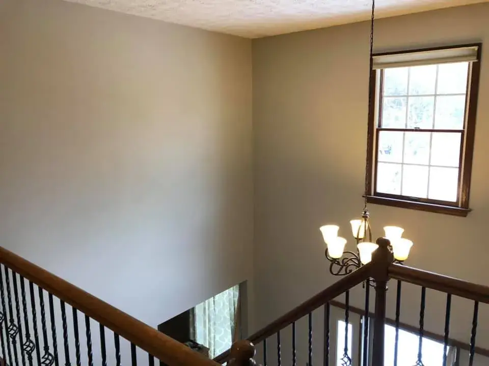 After: two-story foyer with iron balusters painted
