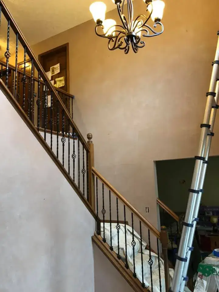 Before: two-story foyer with iron balusters painted