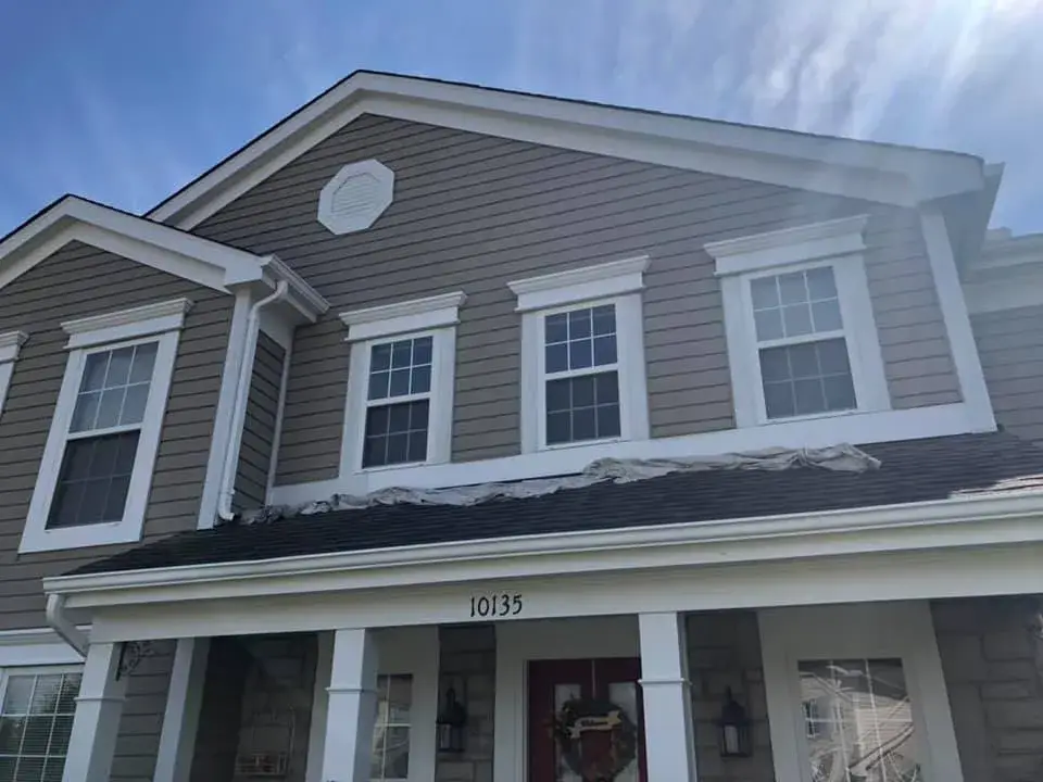 Two-story house with tan siding, white trim, and the street number 10135 above the front door. - My Personal Painter - My Personal Painter In progress: two-story tan siding home exterior trim