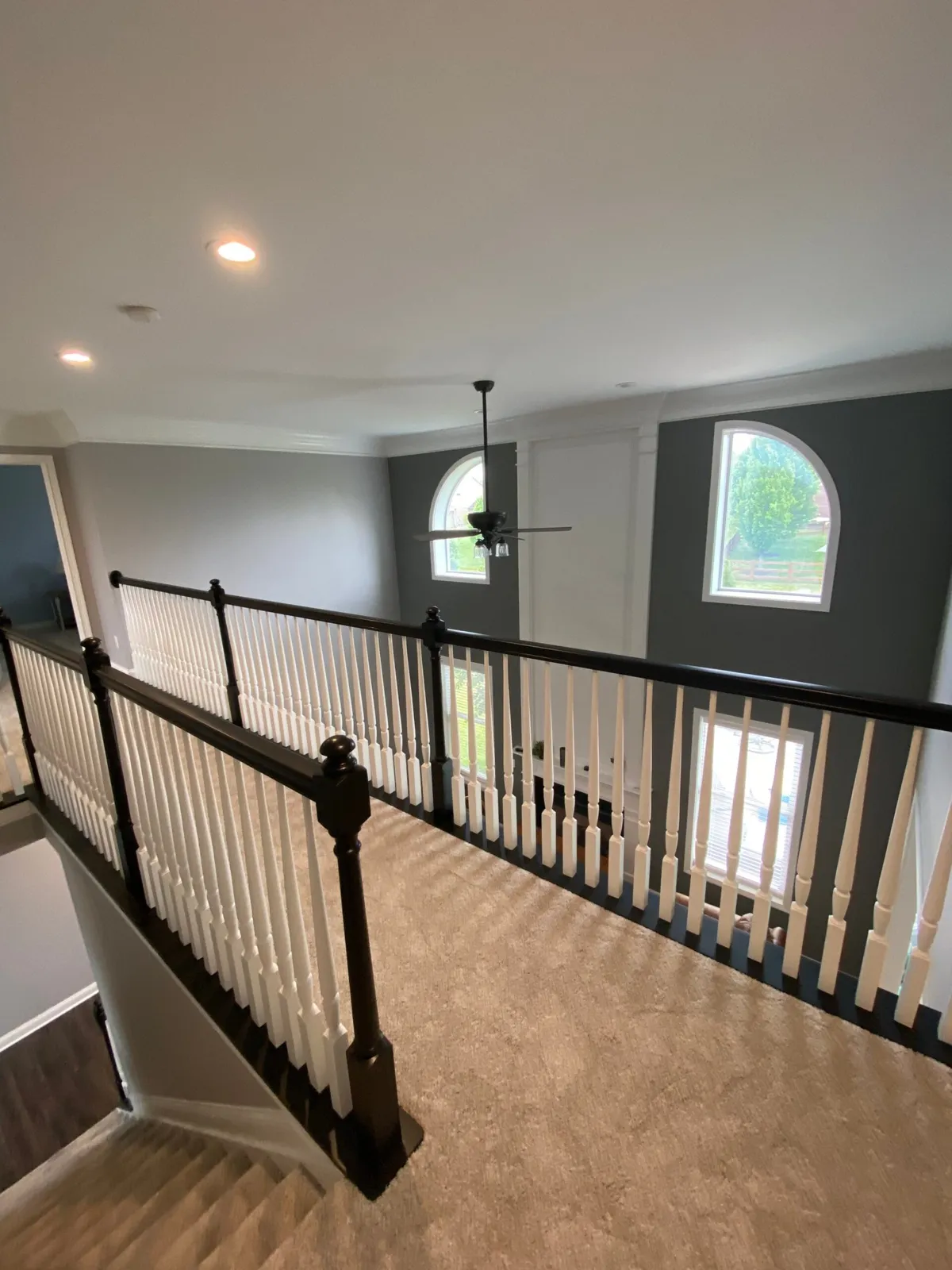 After: upstairs railing painted: black handrail, white spindles