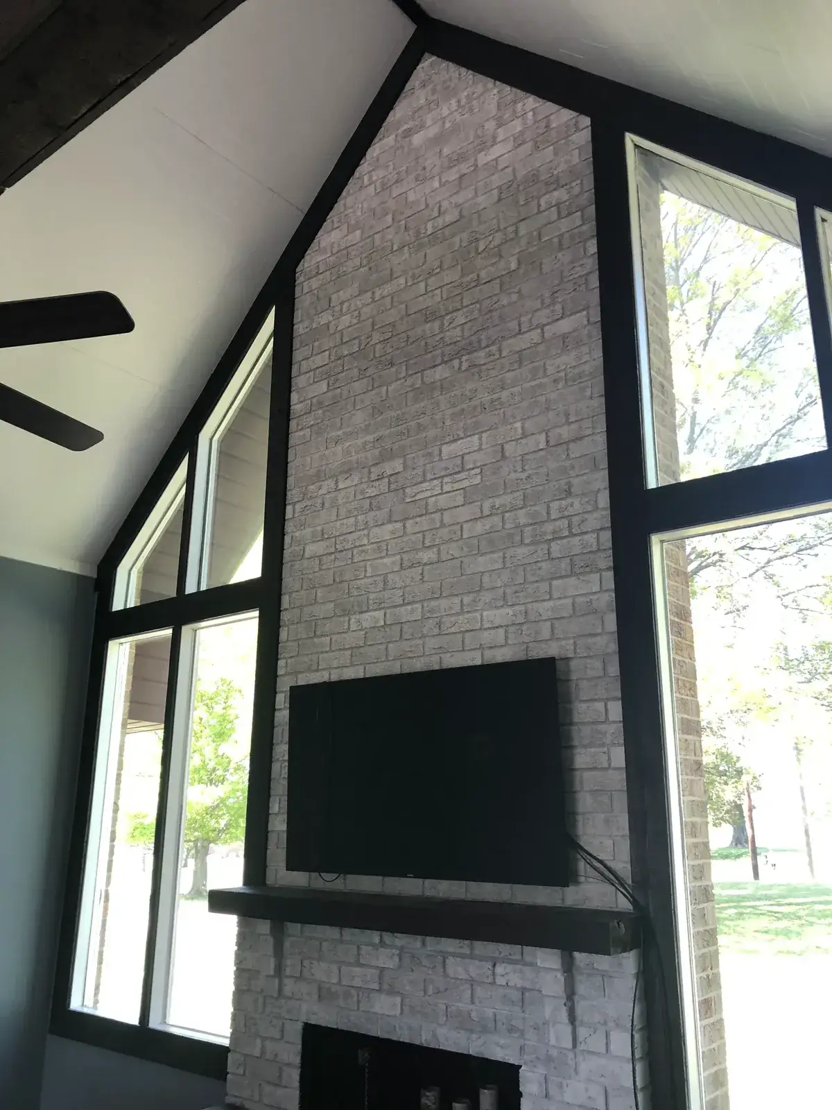 After: vaulted great room: brick chimney painted, then stained wood ceiling to white planks and black beams