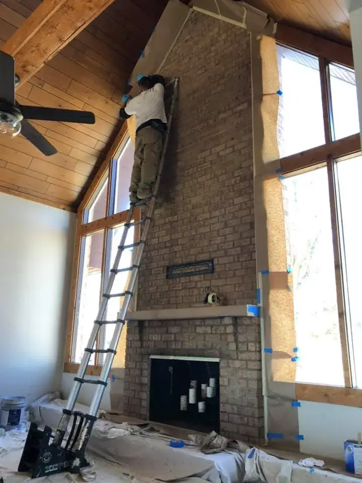Before: vaulted great room: brick chimney painted, then stained wood ceiling to white planks and black beams