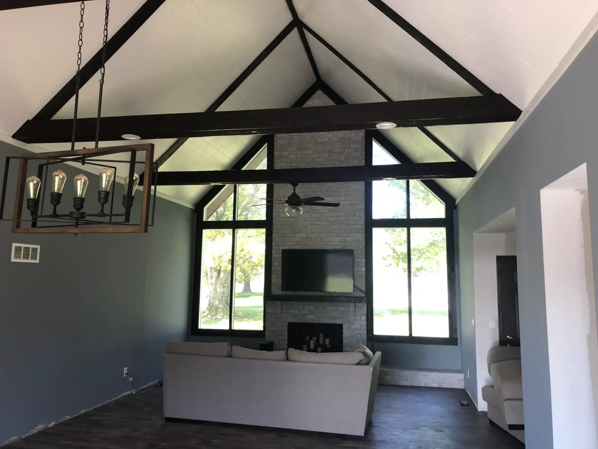 Same vaulted ceiling after painting, white planks with black beams