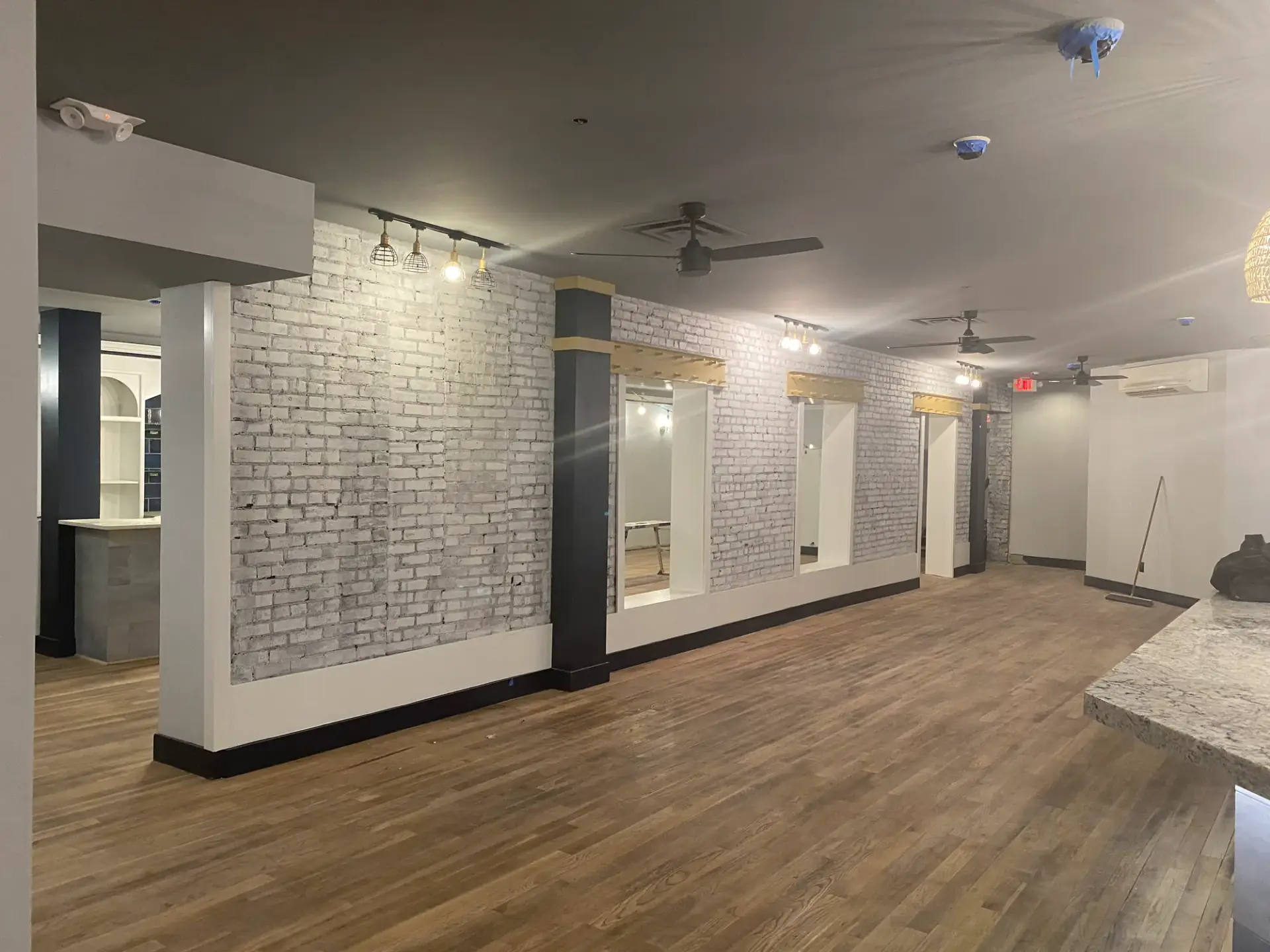 Commercial space with whitewashed brick, black columns and white walls