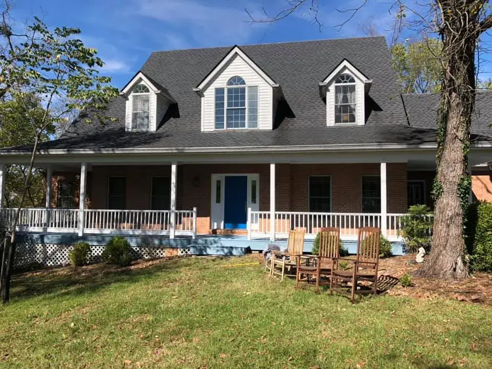 After: wraparound porch on brick Cape Cod: railings white, floor painted blue-gray